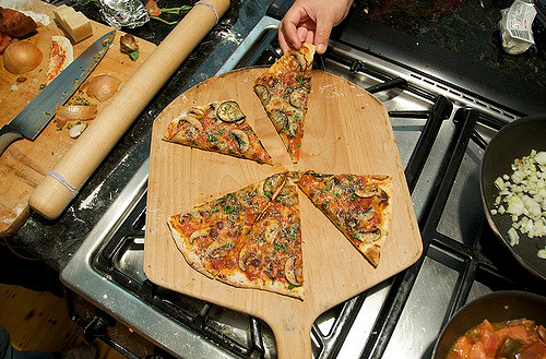 Christine reaches for a slice of pizza.